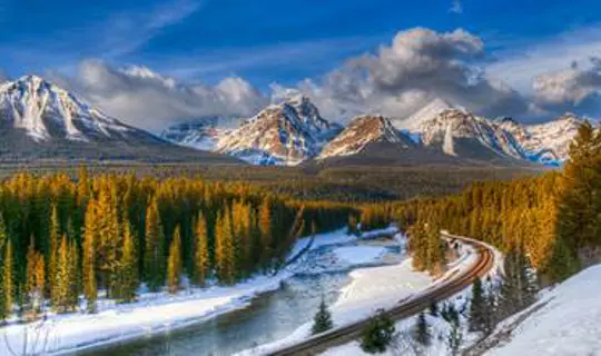 Rail tracks through a snowy Candian mountain range