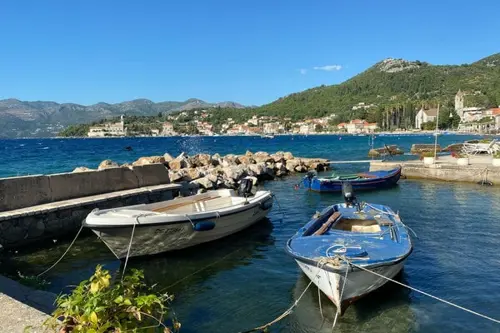 Boats on the sea with mountains in the background in Lopud